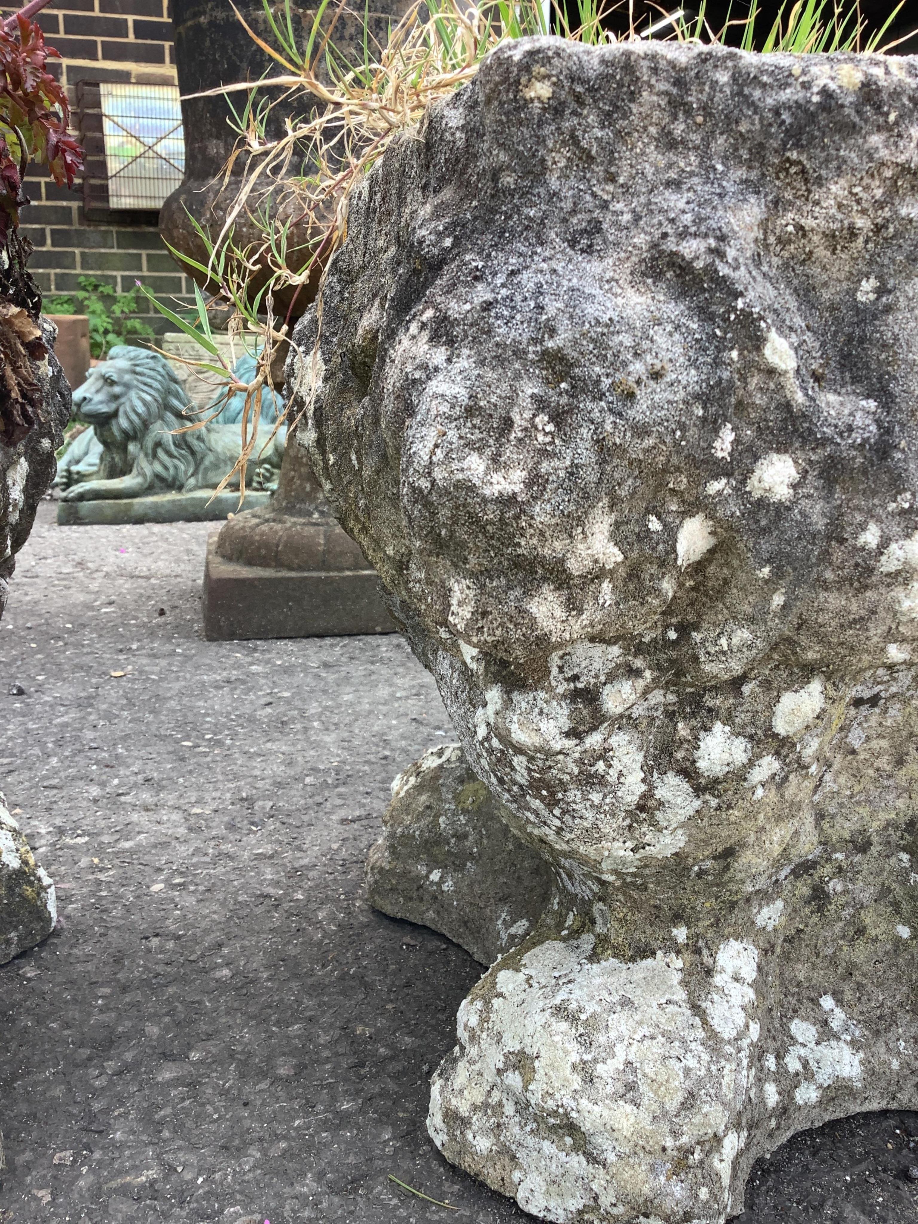 A pair of small reconstituted stone garden urns, moulded with lion masks, width 30cm, height 33cm